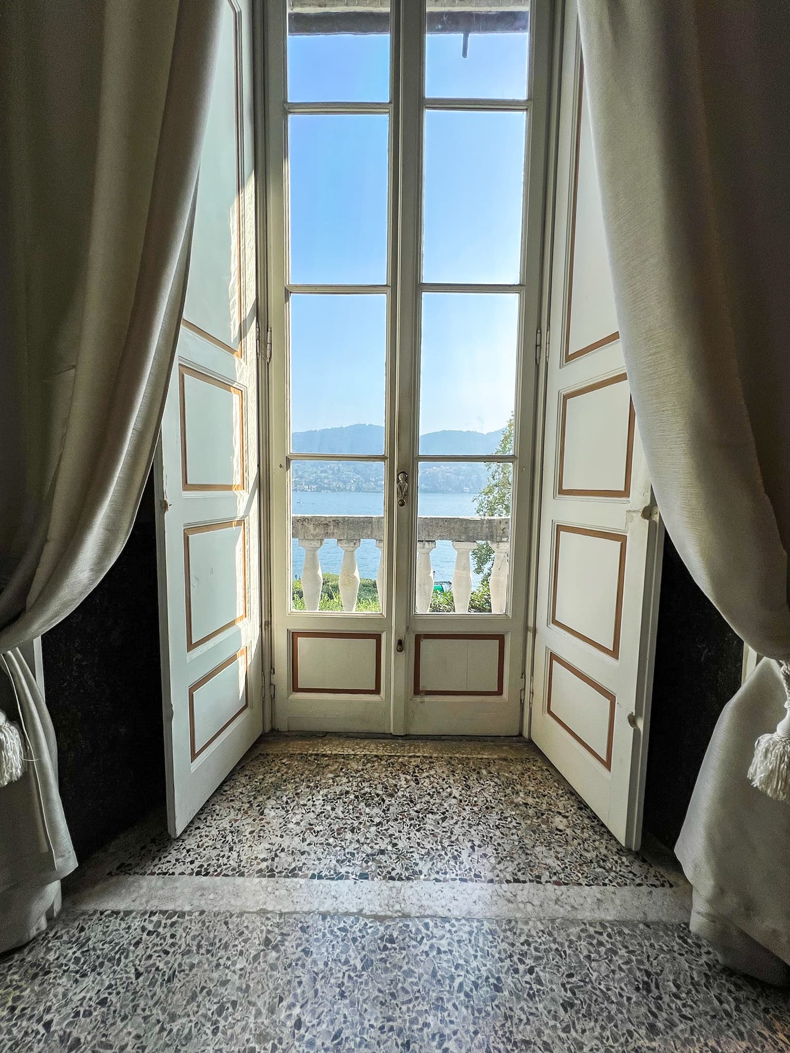 Open French doors onto a lake-view balcony