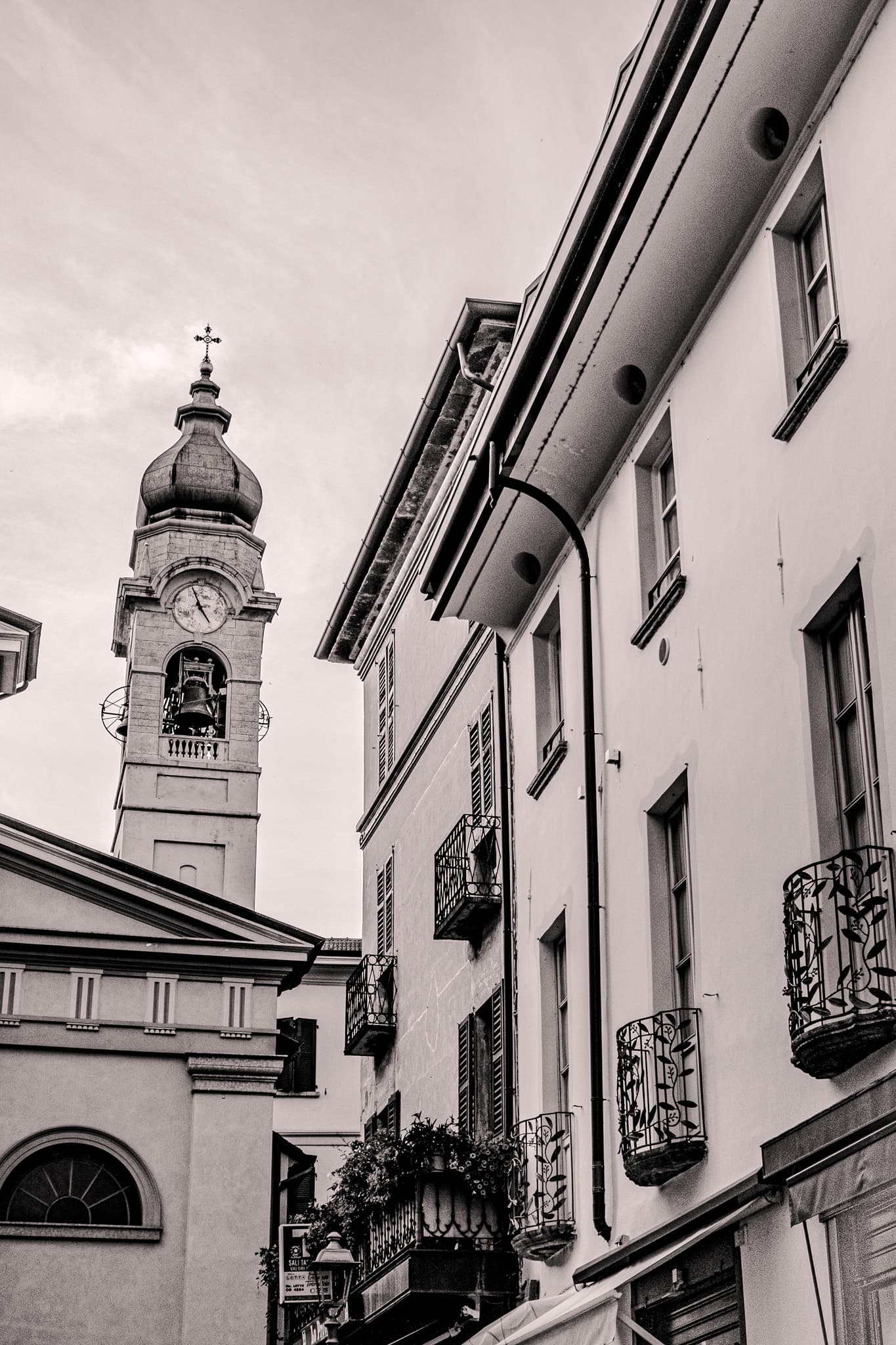 Bell tower rising beside tall shuttered houses