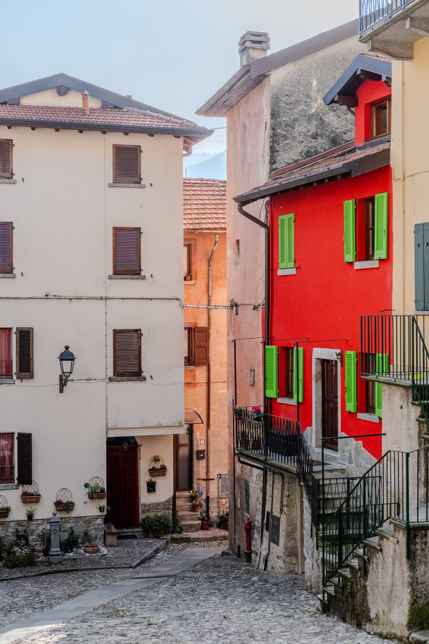 Red house with green shutters on a cobbled street