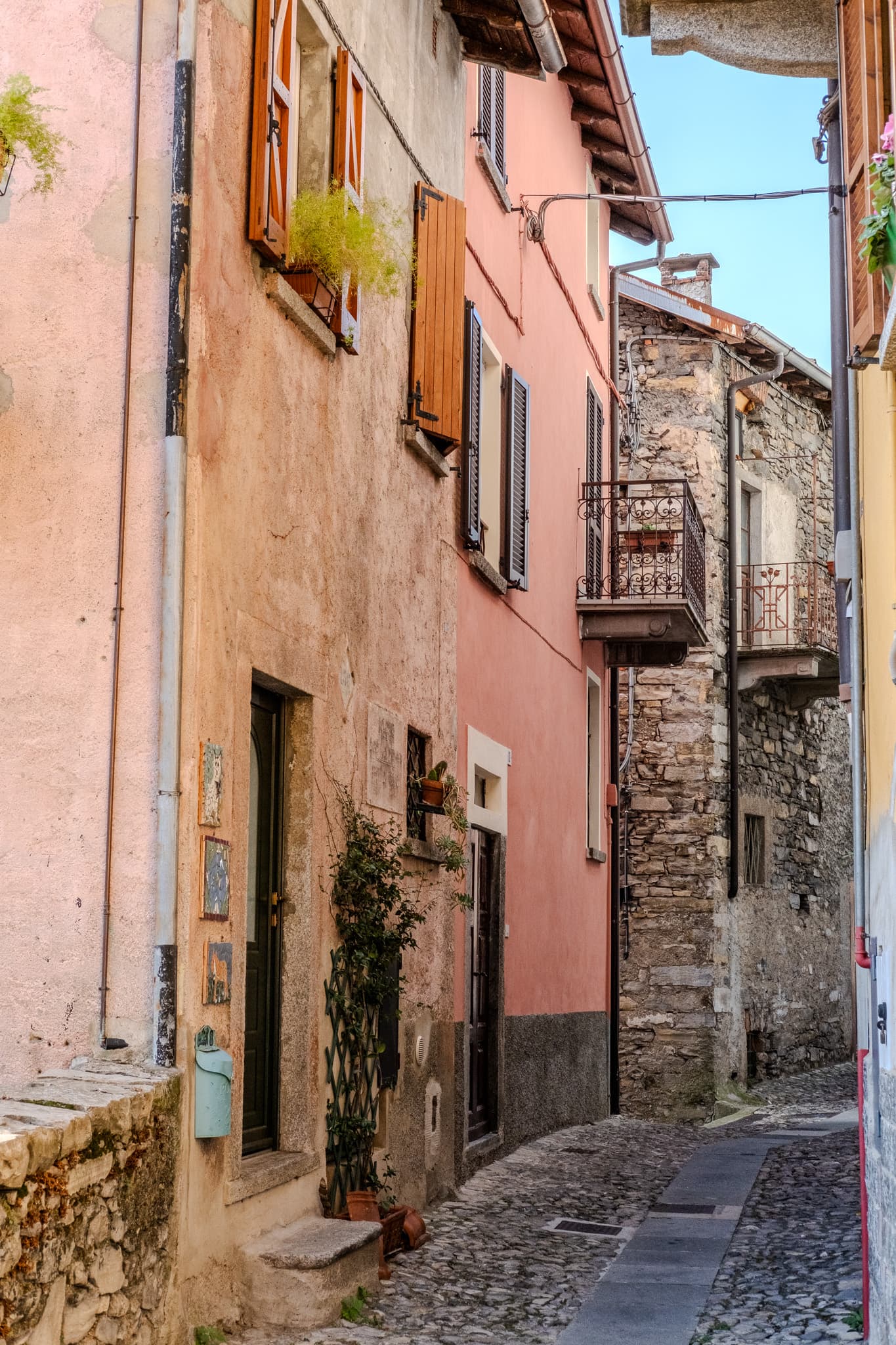 Pink and stone houses along a cobbled lane