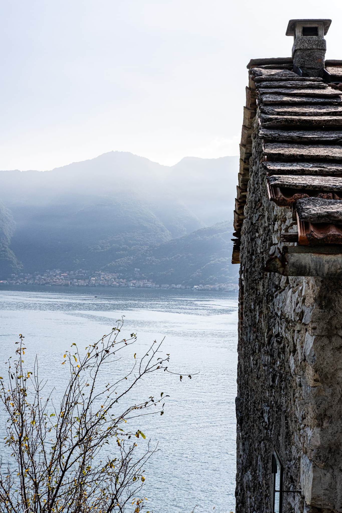 Stone chimney beside a hazy lake and mountains