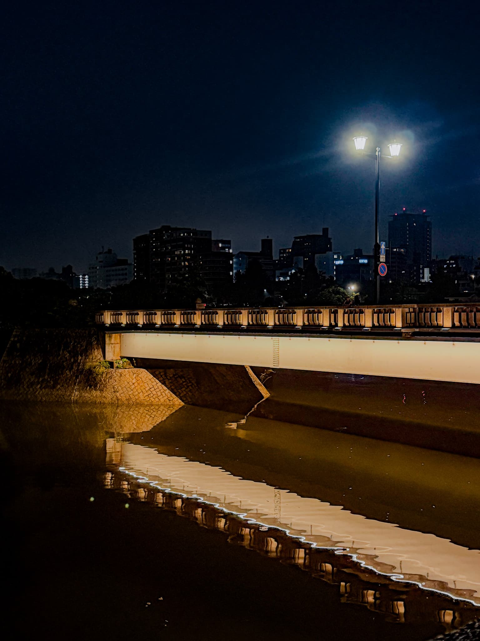 Lit bridge reflected in the river at night