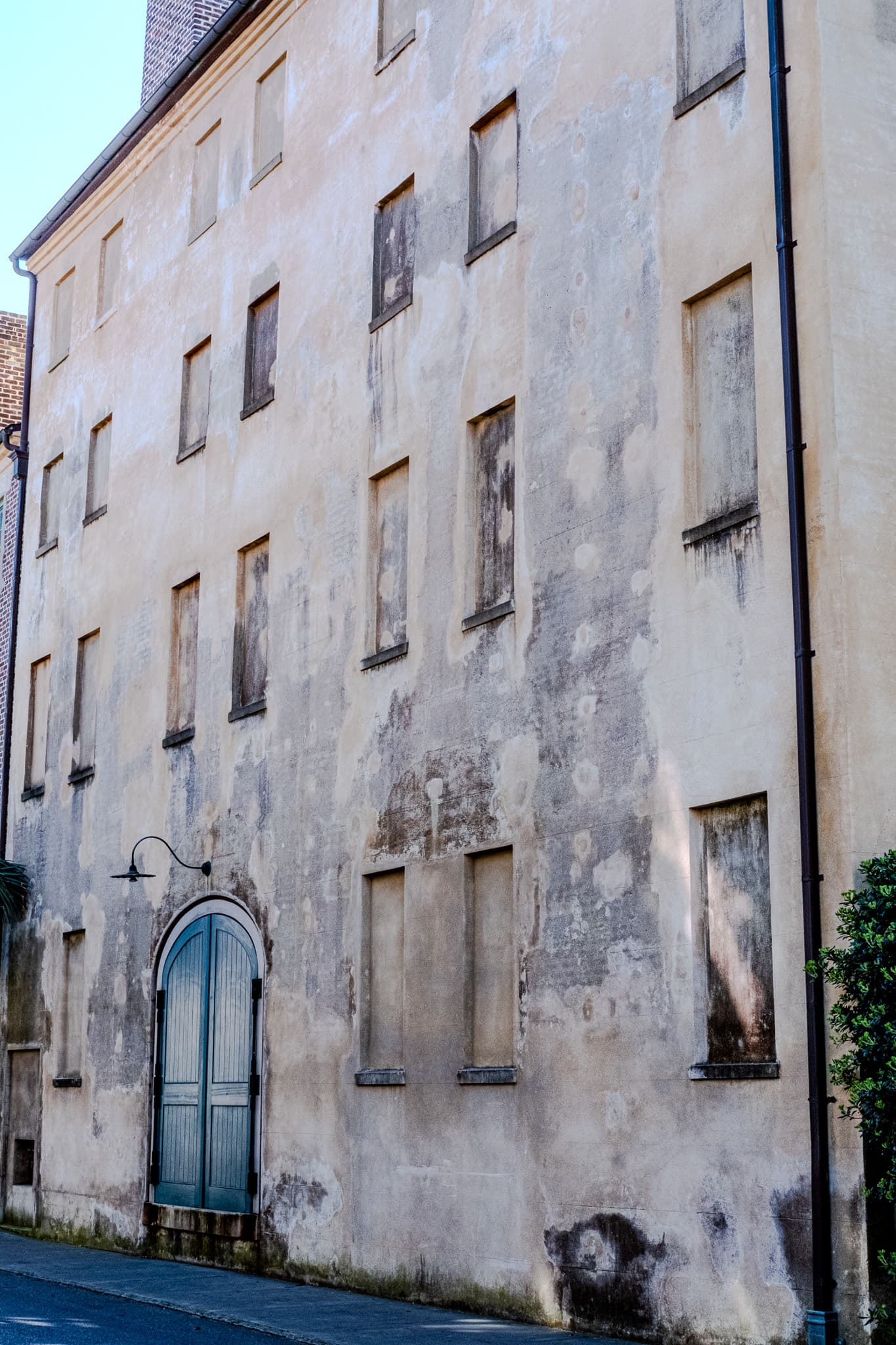 Weathered stucco building with an arched blue door