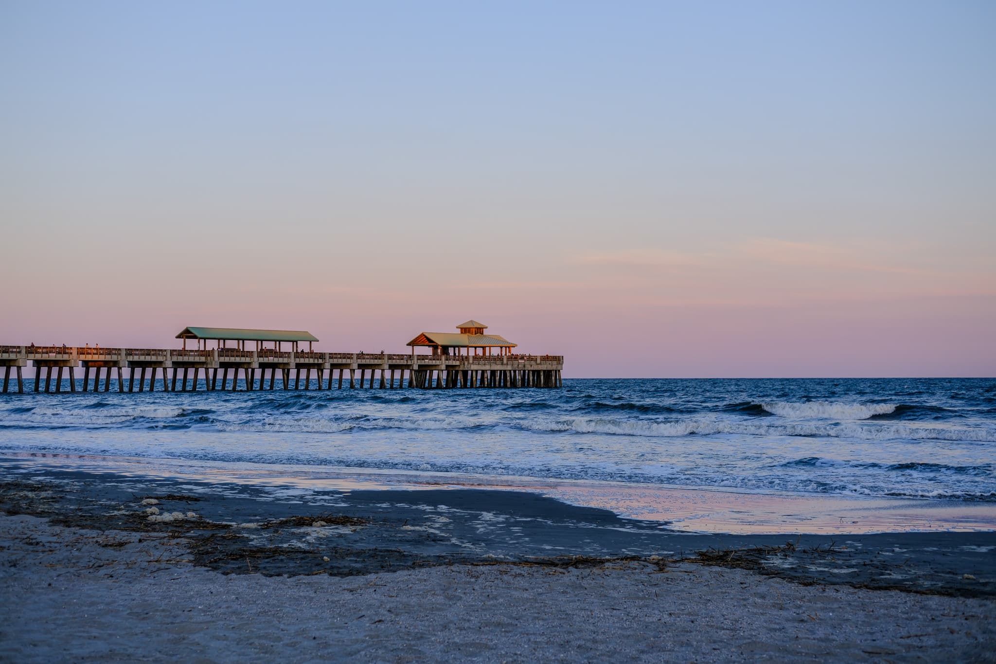 Fishing pier stretching into the ocean at dusk