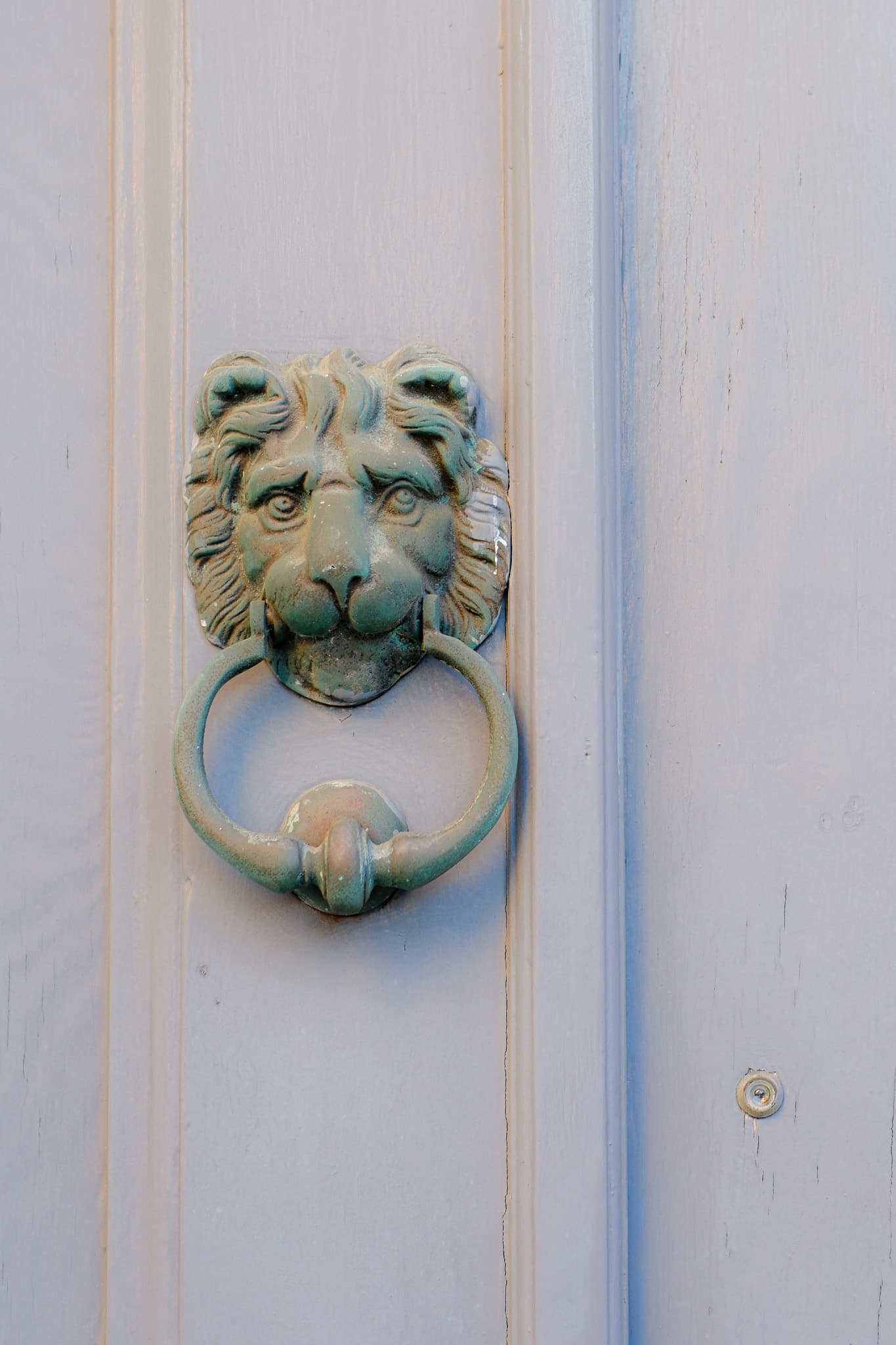 Lion head door knocker on a pale blue door